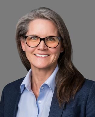 A woman in glasses wearing a shirt and blazer